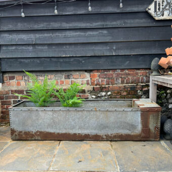 Antique riveted water trough planter